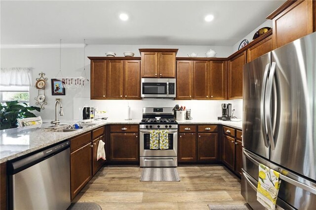 745 Skyview Dr, Commerce, GA 30529 - kitchen featuring stainless steel appliances, a sink, light wood-style floors, light stone countertops, and a peninsula