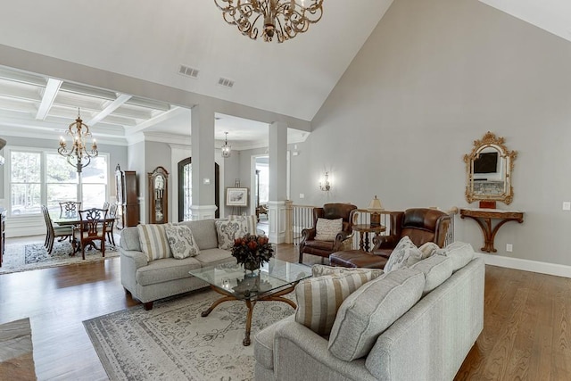living room with visible vents, wood finished floors, a healthy amount of sunlight, and an inviting chandelier