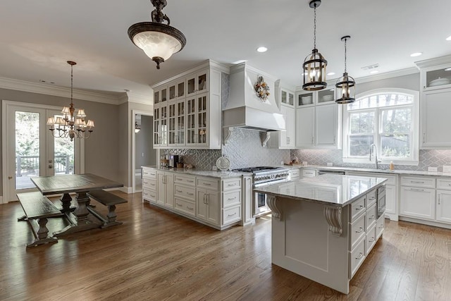 kitchen featuring premium range hood, crown molding, a chandelier, and high end stove