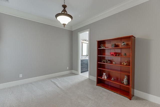 spare room with light carpet, ornamental molding, visible vents, and baseboards