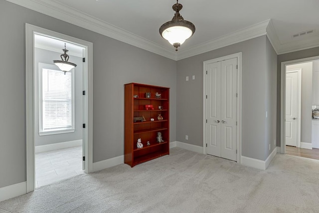 spare room with baseboards, crown molding, visible vents, and carpet