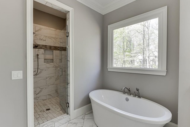bathroom with baseboards, a freestanding tub, marble finish floor, a shower stall, and crown molding