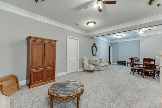 living area featuring light colored carpet, ceiling fan, and crown molding