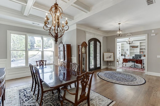dining space featuring ornamental molding, a notable chandelier, wood finished floors, and visible vents