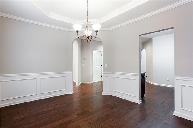 unfurnished dining area featuring dark hardwood / wood-style flooring, ornamental molding, a tray ceiling, and an inviting chandelier