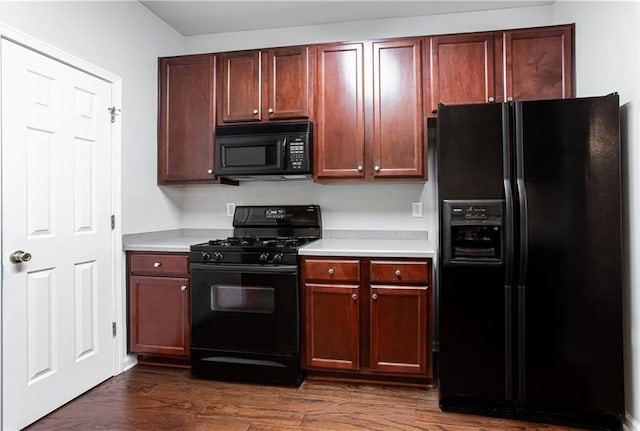 kitchen with dark wood-type flooring and black appliances