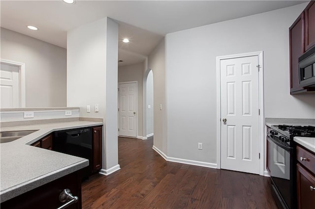 kitchen with black appliances, dark hardwood / wood-style flooring, and sink