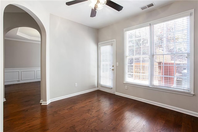 unfurnished room with ceiling fan, dark hardwood / wood-style flooring, crown molding, and a wealth of natural light