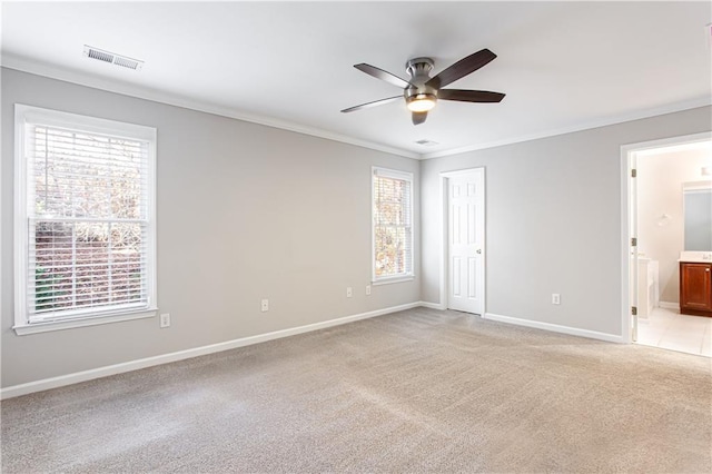 empty room with light colored carpet, ceiling fan, and ornamental molding