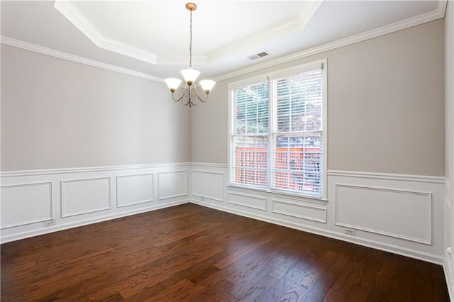 empty room featuring a raised ceiling, crown molding, dark hardwood / wood-style floors, and an inviting chandelier