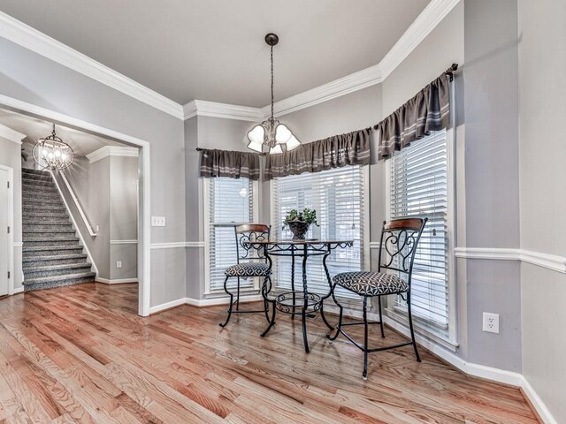 5090 Eubanks Rd, Woodstock, GA 30188 - dining room with a chandelier, stairs, wood finished floors, and crown molding
