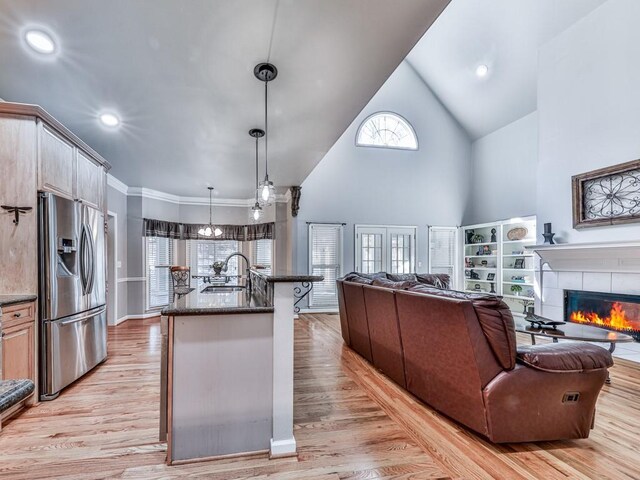5090 Eubanks Rd, Woodstock, GA 30188 - kitchen featuring stainless steel fridge with ice dispenser, a sink, open floor plan, high vaulted ceiling, and light wood finished floors