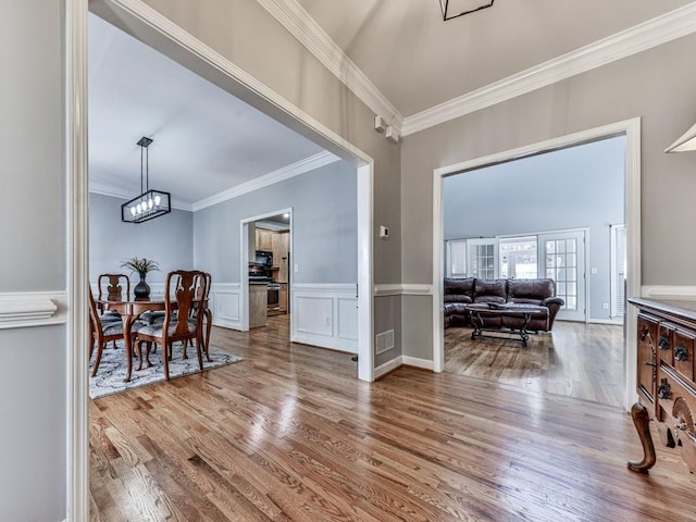 5090 Eubanks Rd, Woodstock, GA 30188 - dining room featuring crown molding, wood finished floors, wainscoting, and a chandelier