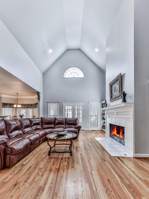 5090 Eubanks Rd, Woodstock, GA 30188 - living room with high vaulted ceiling, a tiled fireplace, wood finished floors, and a chandelier