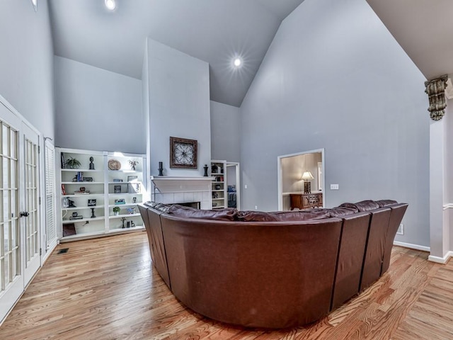 5090 Eubanks Rd, Woodstock, GA 30188 - living room featuring high vaulted ceiling, wood finished floors, a tiled fireplace, baseboards, and recessed lighting