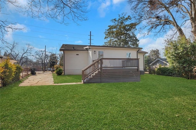 back of house with a wooden deck and a lawn