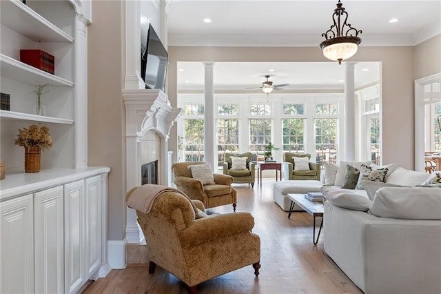 6191 Talmadge Run, Acworth, GA 30101 - living room with a glass covered fireplace, a ceiling fan, ornate columns, and a healthy amount of sunlight