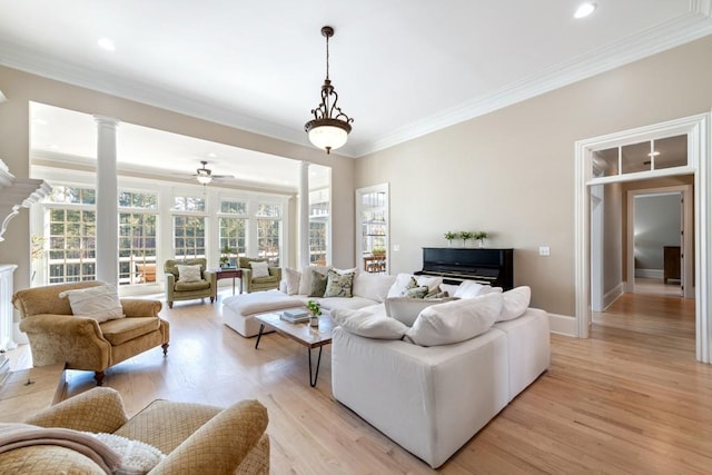 living room with light wood-type flooring, decorative columns, ceiling fan, and ornamental molding