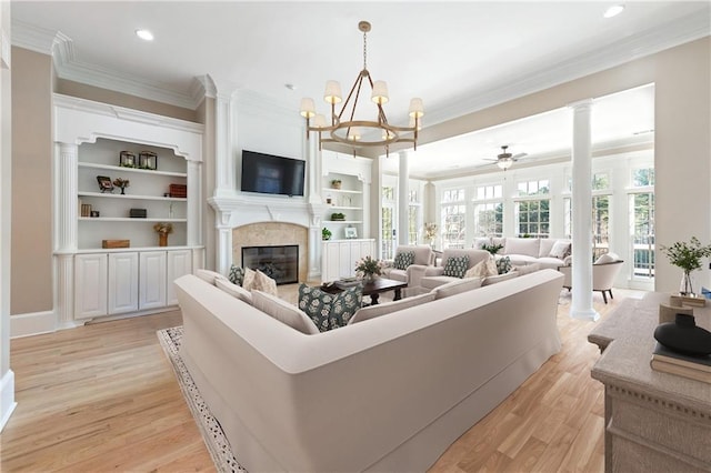6191 Talmadge Run, Acworth, GA 30101 - living area with a glass covered fireplace, crown molding, light wood-style floors, and ceiling fan with notable chandelier
