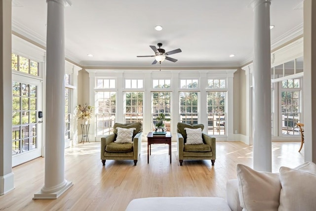 sunroom featuring ceiling fan and ornate columns