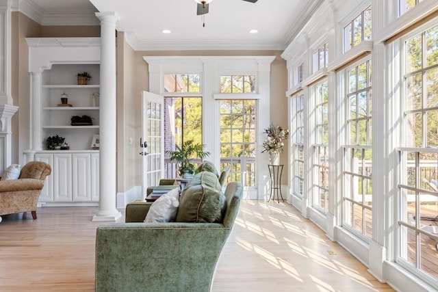 sunroom with a wealth of natural light, ceiling fan, and ornate columns