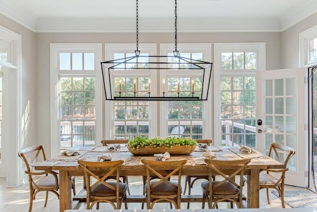 dining area featuring a healthy amount of sunlight and crown molding