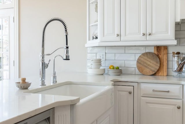 kitchen with tasteful backsplash, sink, and white cabinets