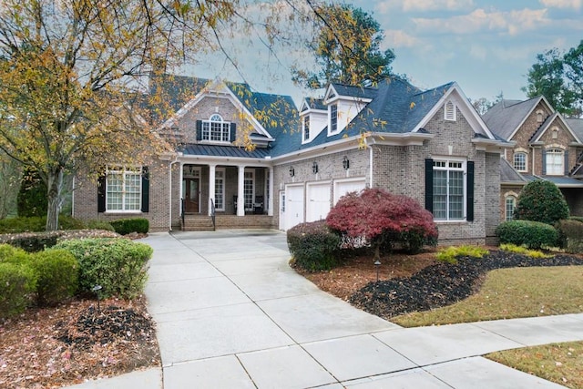 view of front of home with a garage, brick siding, a porch, and concrete driveway