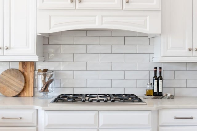 kitchen featuring white cabinets, backsplash, and stainless steel gas cooktop