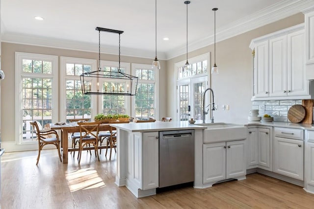 kitchen with dishwasher, ornamental molding, a peninsula, white cabinets, and a sink