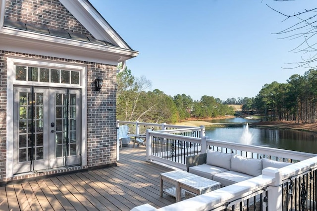 deck with an outdoor living space, french doors, and a water view