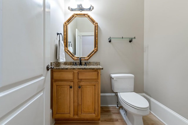 bathroom with hardwood / wood-style floors, vanity, and toilet