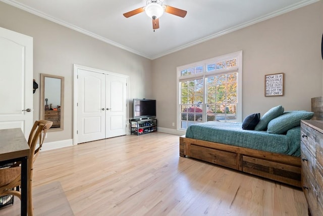 bedroom featuring ceiling fan, baseboards, light wood-style flooring, and ornamental molding