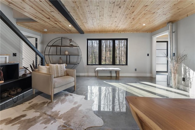 living area featuring wood ceiling, concrete flooring, and beamed ceiling