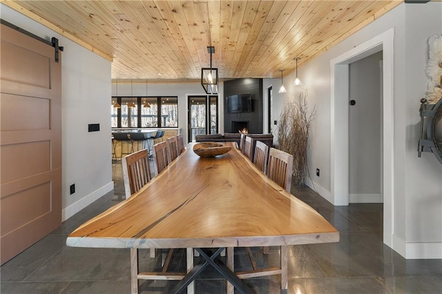 dining space featuring wood ceiling and a barn door