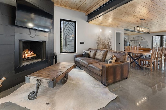 living room featuring an inviting chandelier, wood ceiling, a fireplace, and beamed ceiling