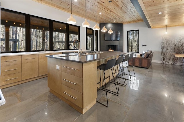 bar featuring sink, wood ceiling, decorative light fixtures, and a large fireplace