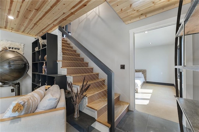 stairway with concrete floors and wood ceiling