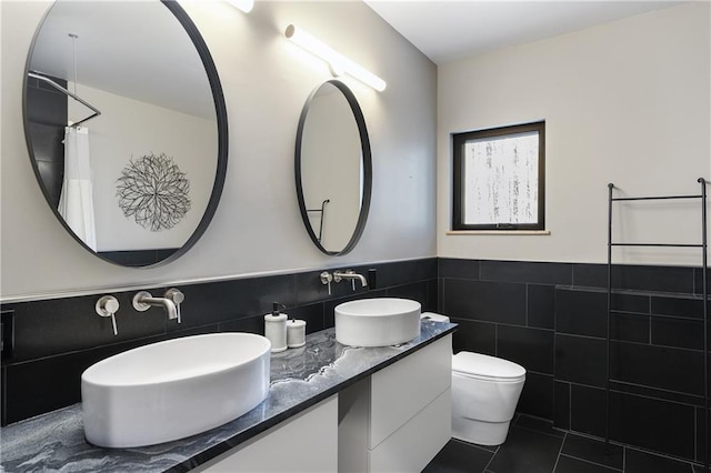 bathroom featuring tile walls, vanity, curtained shower, tile patterned floors, and toilet