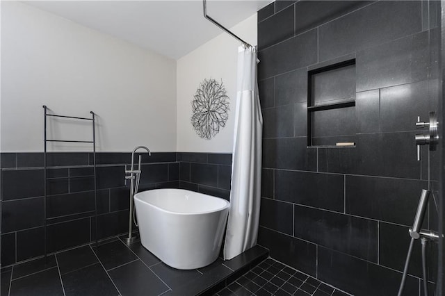 bathroom with independent shower and bath, tile patterned flooring, and tile walls