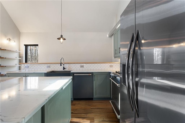 kitchen featuring dark wood-type flooring, sink, appliances with stainless steel finishes, pendant lighting, and decorative backsplash