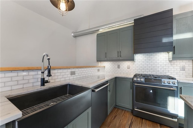 kitchen featuring lofted ceiling, sink, gas stove, stainless steel dishwasher, and exhaust hood