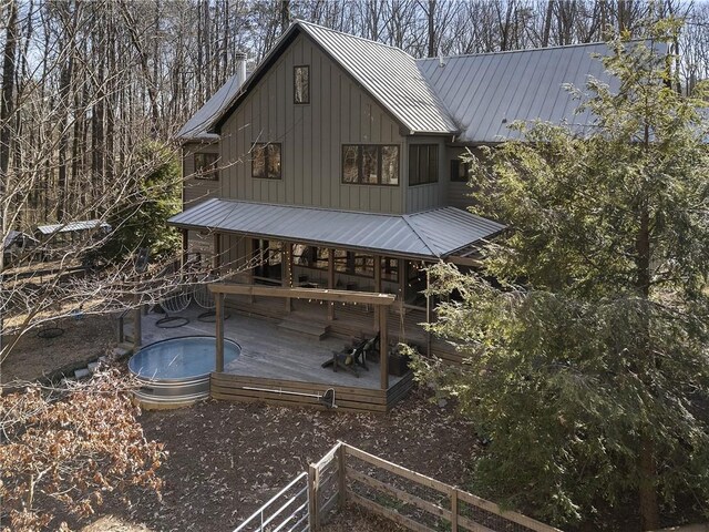 rear view of property featuring a swimming pool side deck