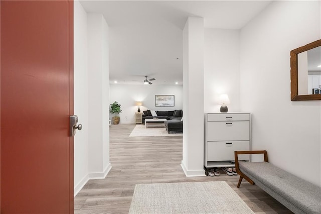 corridor featuring baseboards and light wood finished floors