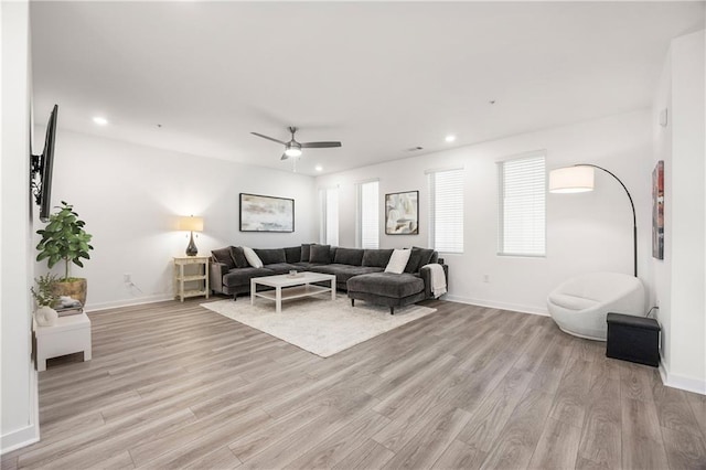 living room with light wood finished floors, recessed lighting, and baseboards