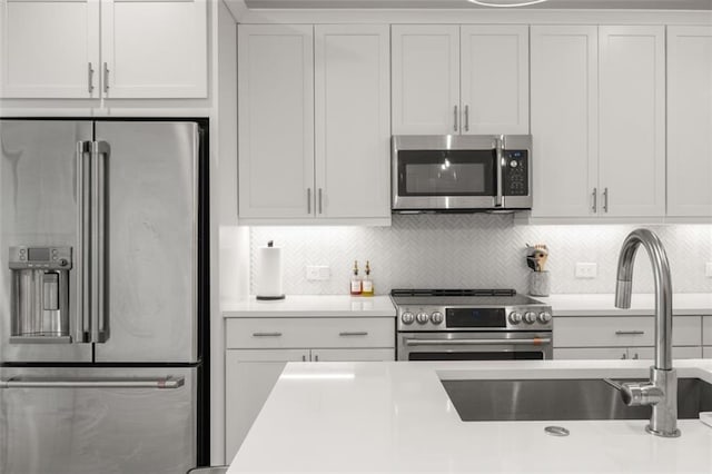 kitchen featuring a sink, light countertops, white cabinets, and stainless steel appliances