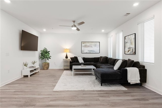 living room featuring ceiling fan and light hardwood / wood-style flooring