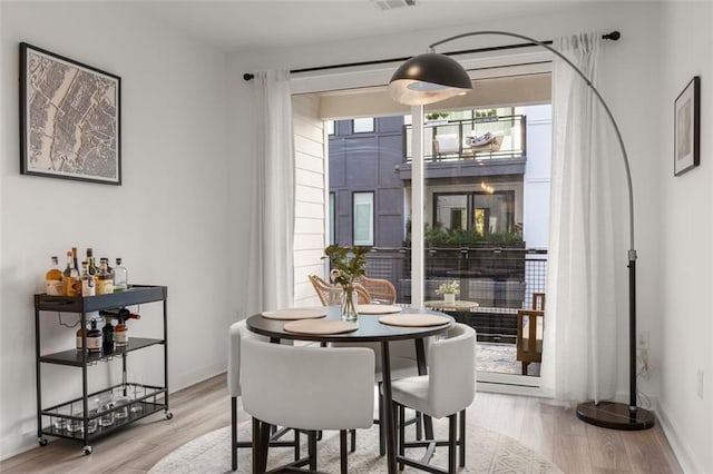 dining area featuring light wood-type flooring and baseboards