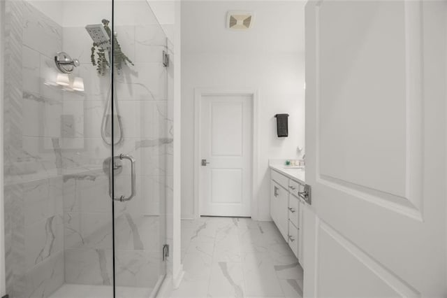 bathroom featuring a marble finish shower, marble finish floor, and vanity