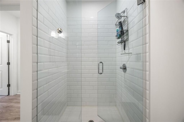 bathroom featuring wood finished floors and a stall shower